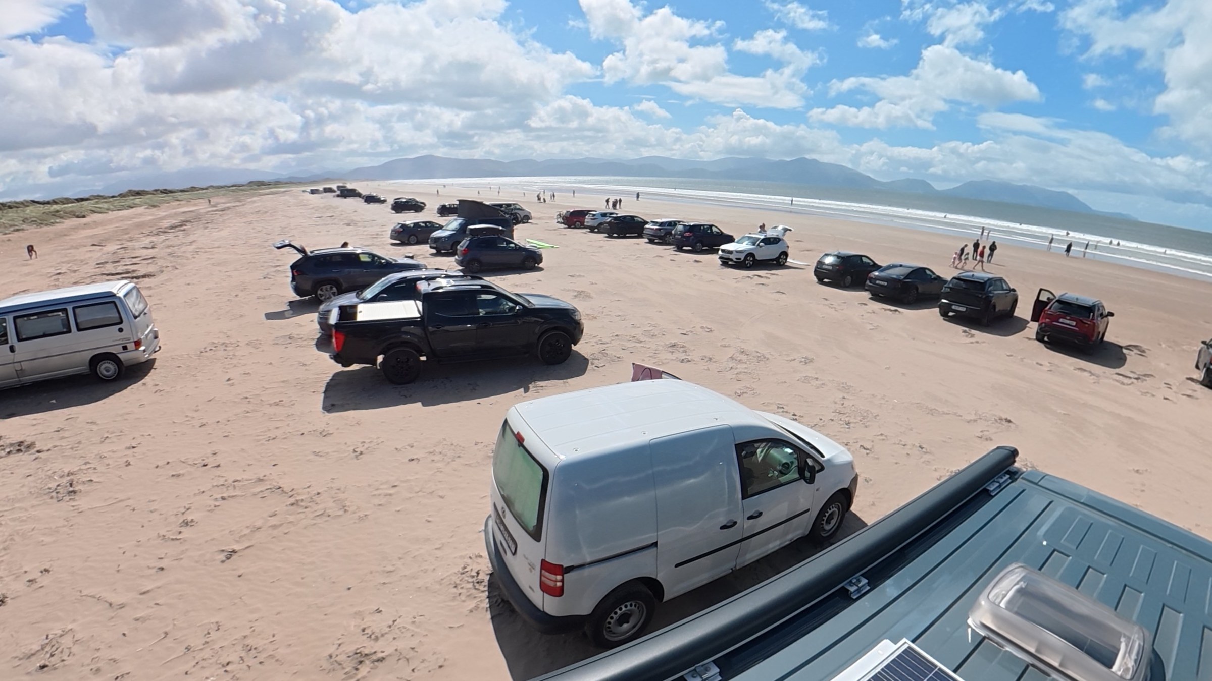 Cars and campervans parked across the sand at Inch Beach