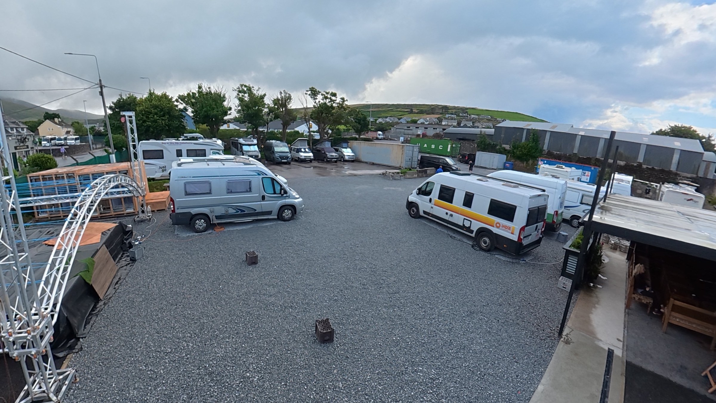 Campervans filling the gravel pitches at Dingle Bridge House Camping