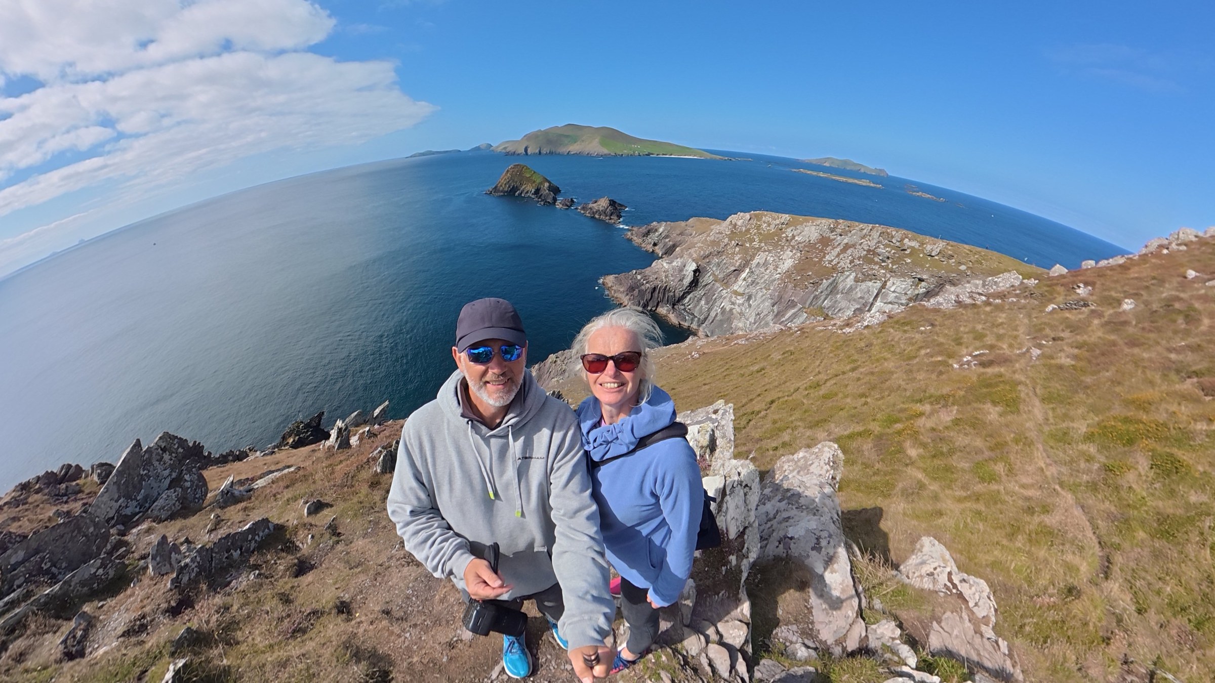 Sue and John standing above Dunmore Head with the Blaskets behind