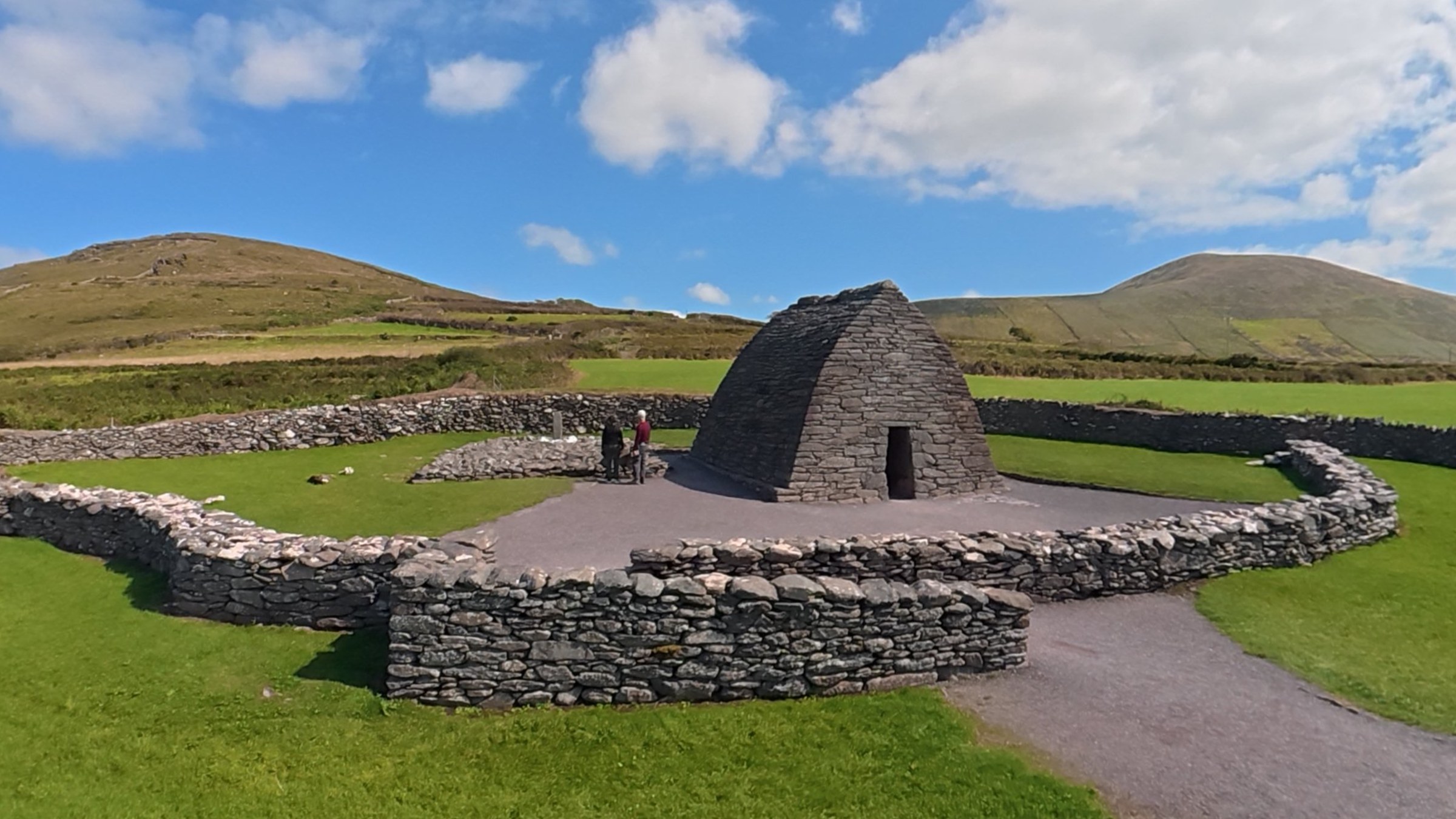 Gallarus Oratory standing inside its circular stone enclosure