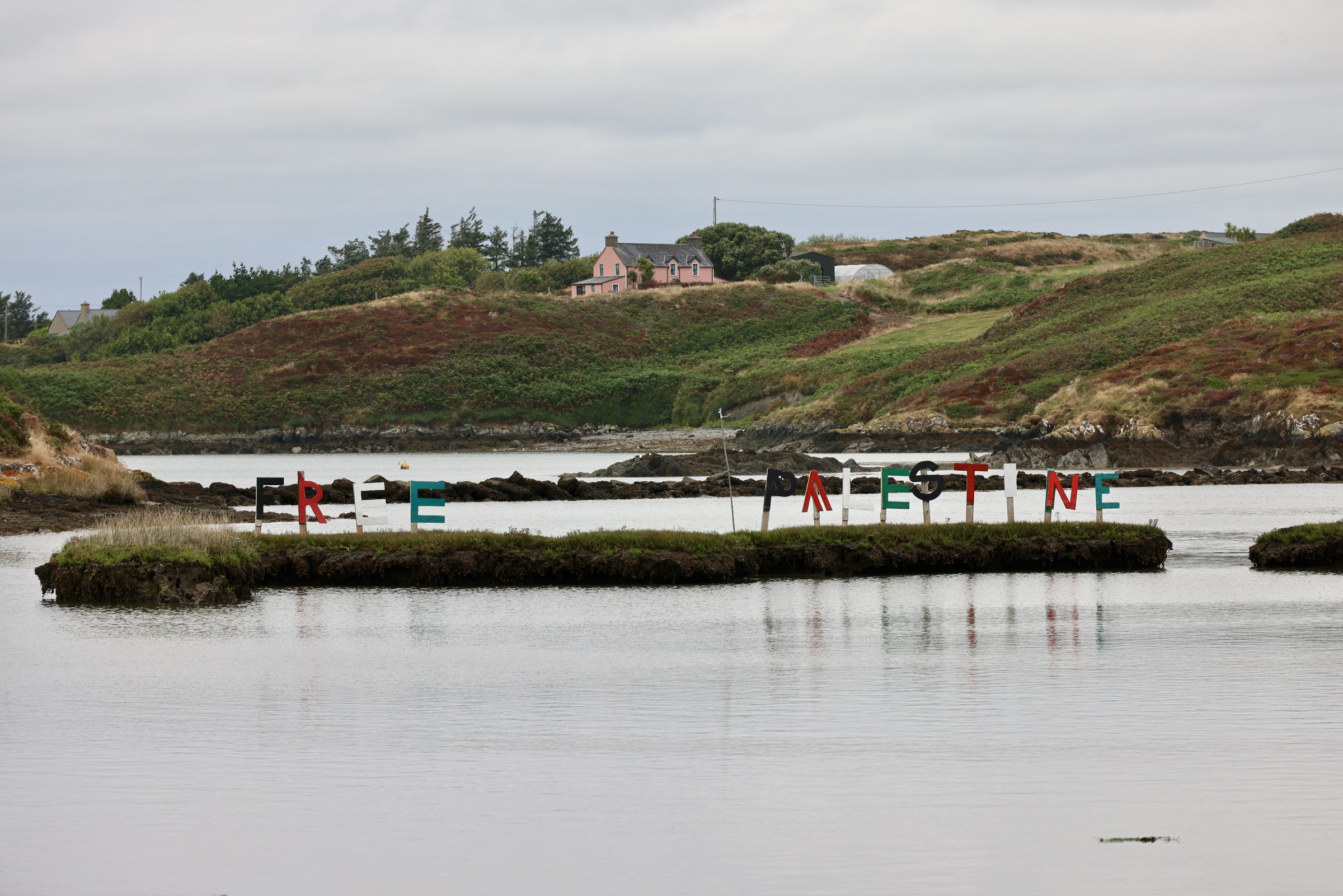 Free Palestine message arranged in coloured letters across a lagoon