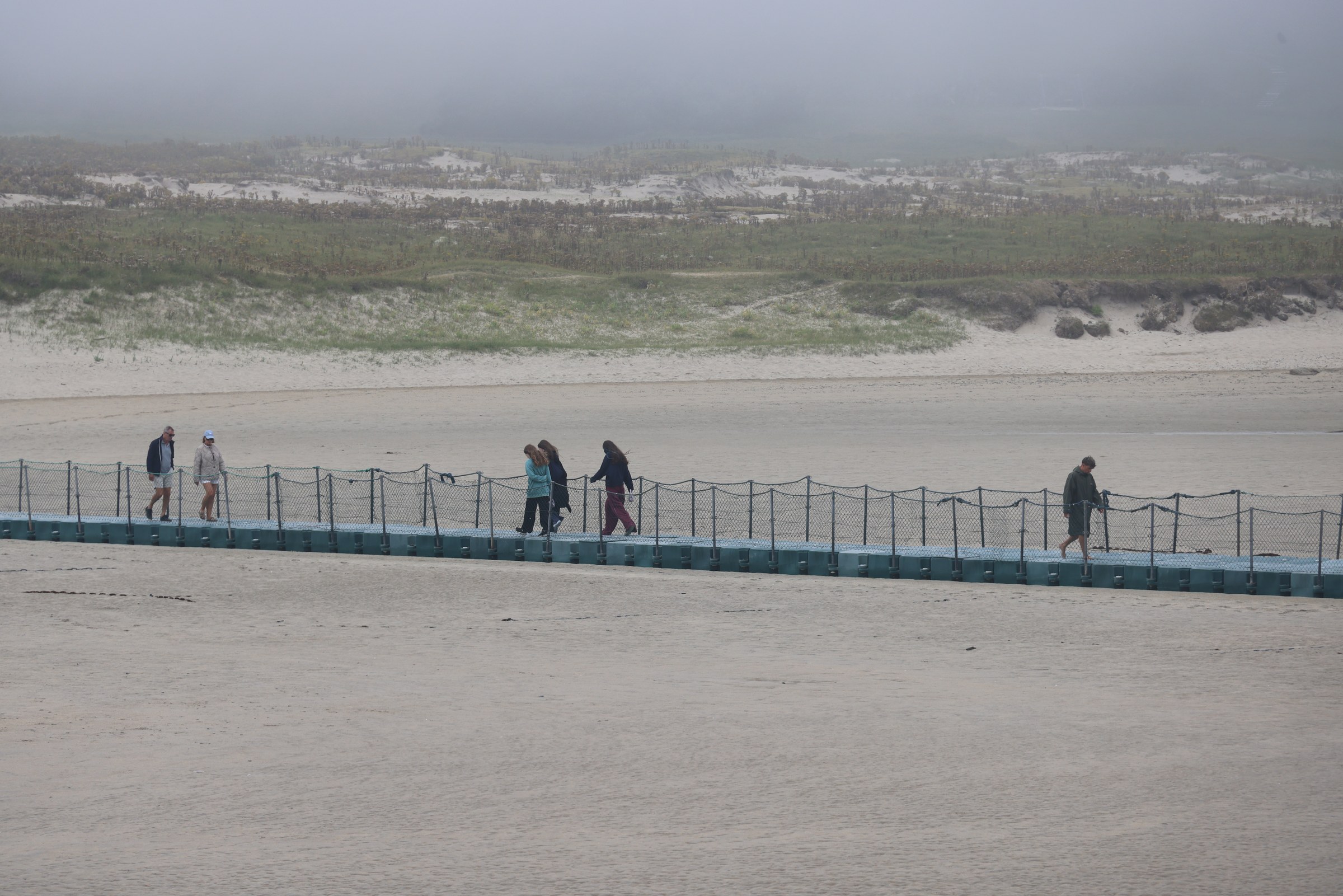 People crossing the floating pontoon at Barleycove
