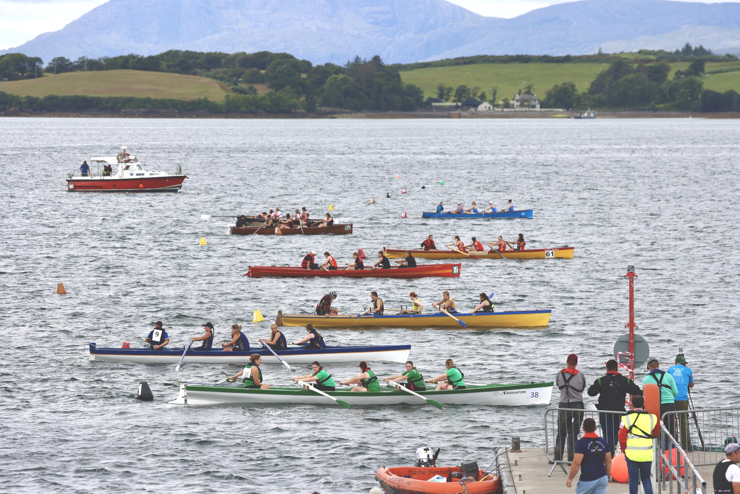 Several coastal rowing crews racing away from the Bantry shoreline