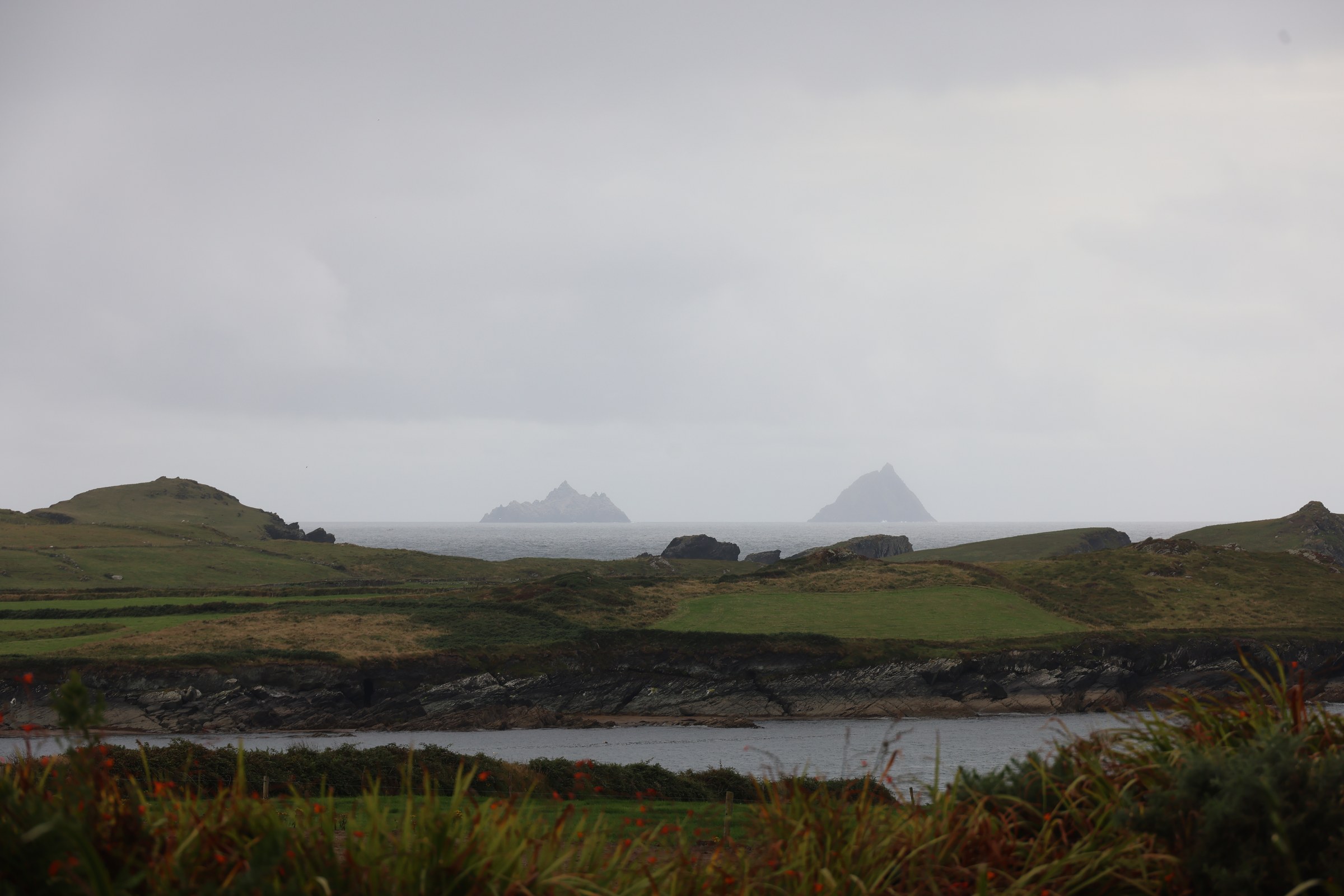The Skellig Islands appearing through mist beyond Valentia's rocky coast