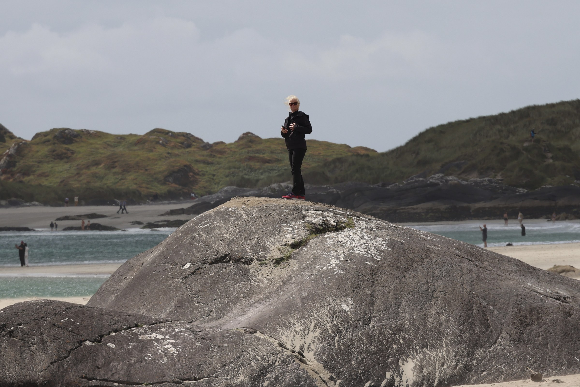 Sue standing on a large rock at Derrynane Beach