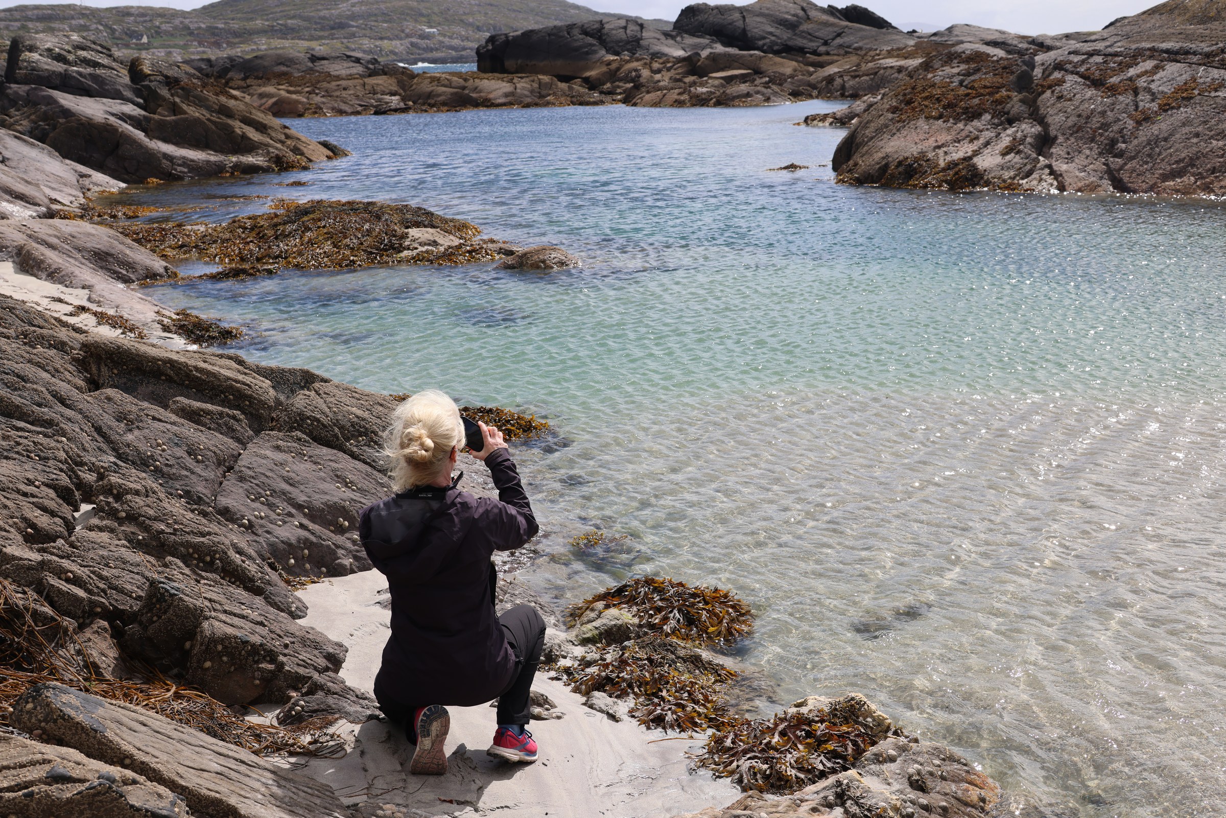 Clear rock pools among dark rocks at Derrynane Beach