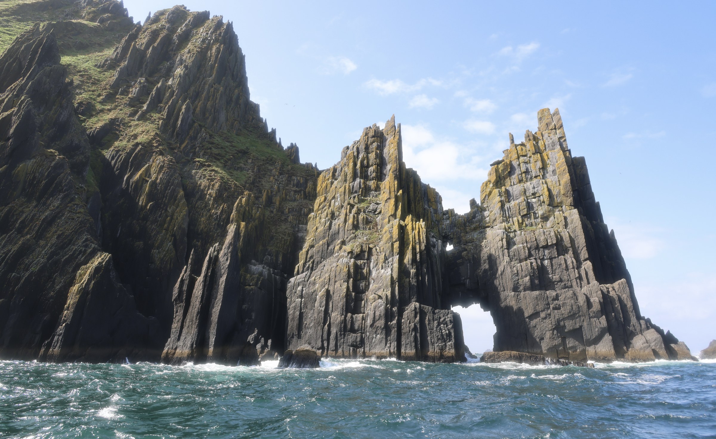 The jagged Cathedral Rocks and sea arch of Inis na Bró