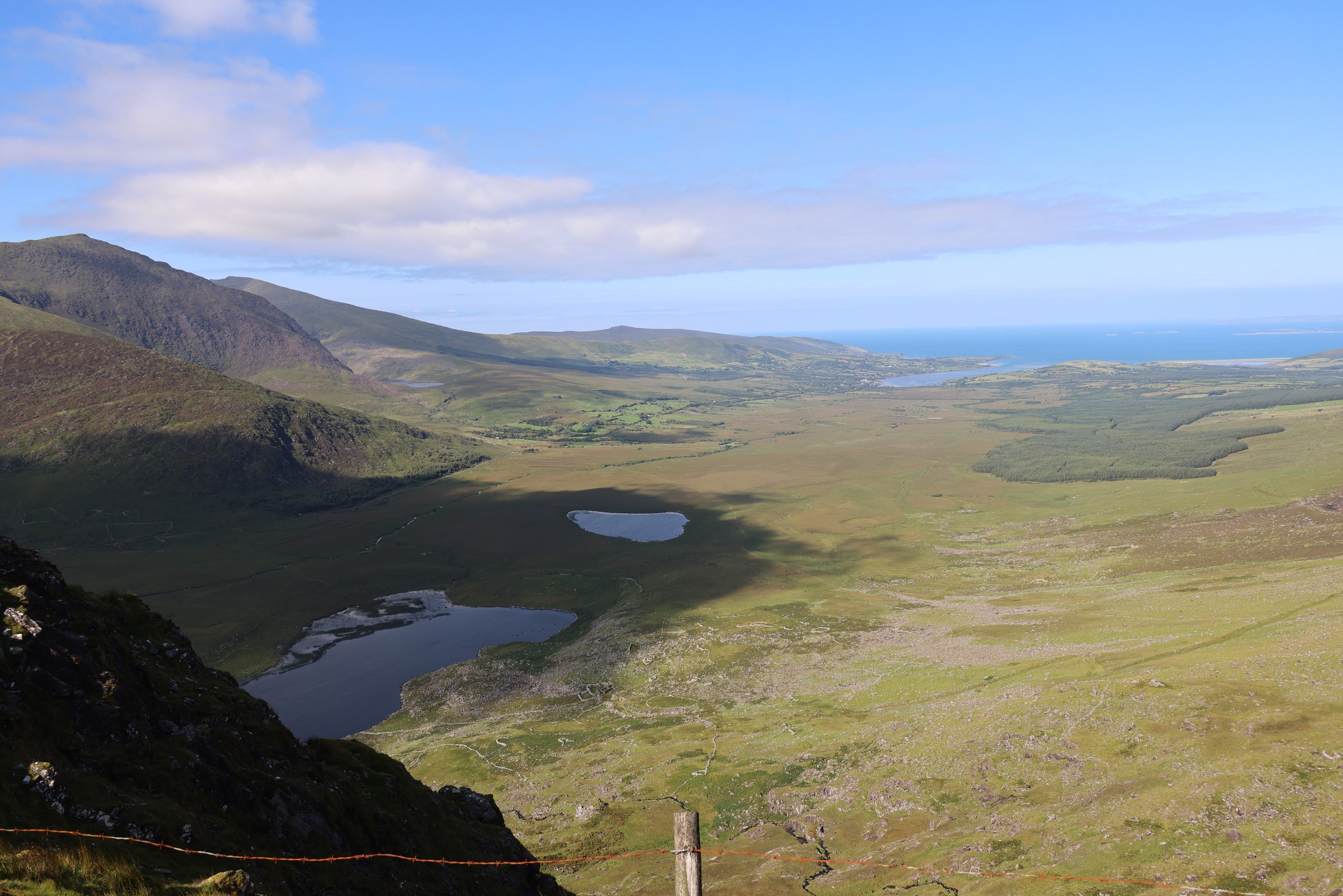 The narrow Conor Pass road descending between steep slopes and corrie lakes