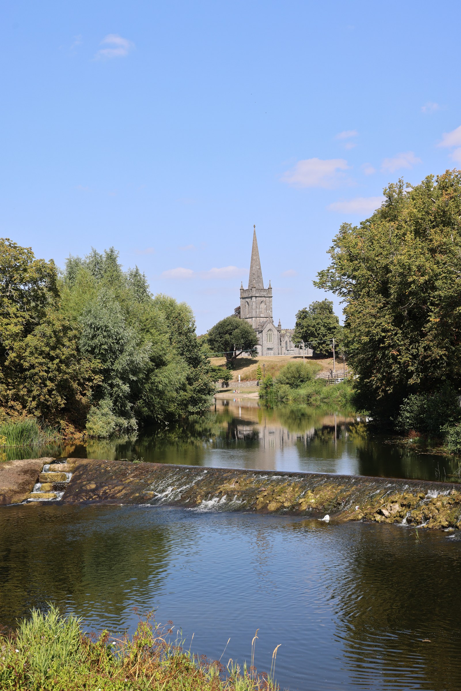 A church spire seen across the River Suir from the weir in Cahir