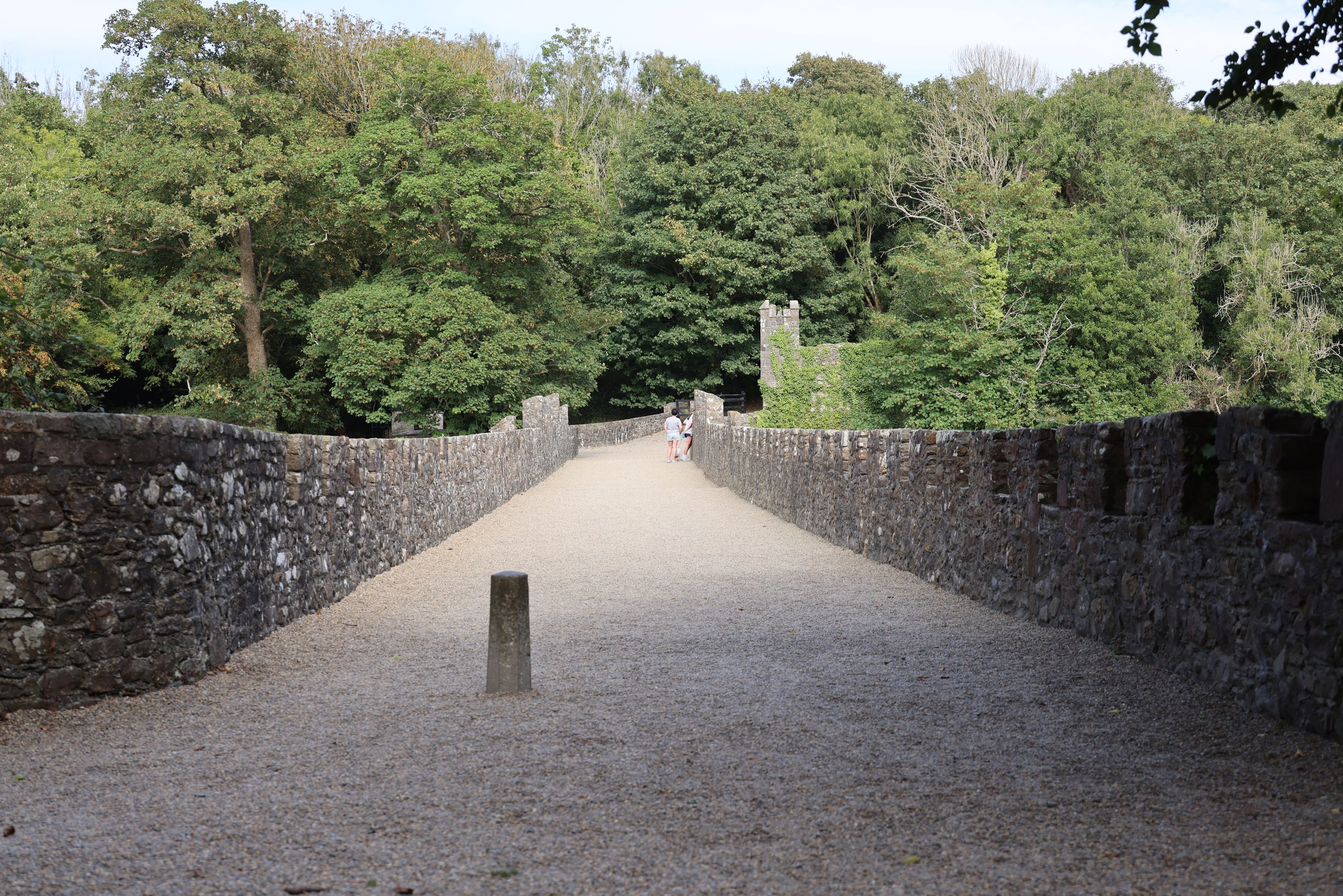 The long gravel surface and stone parapets of the bridge at Tintern Abbey