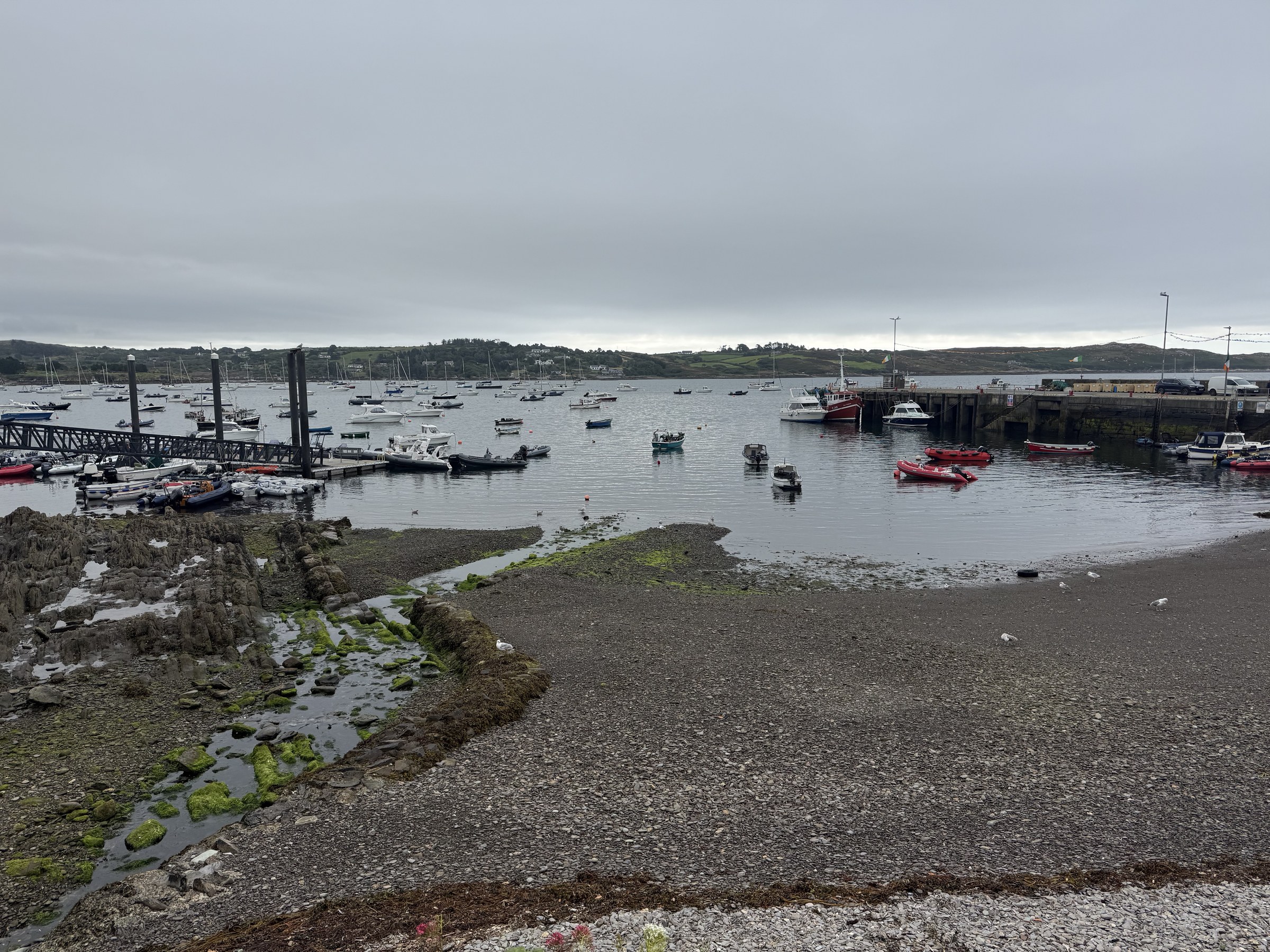 Boats moored in Schull Harbour beneath a grey sky