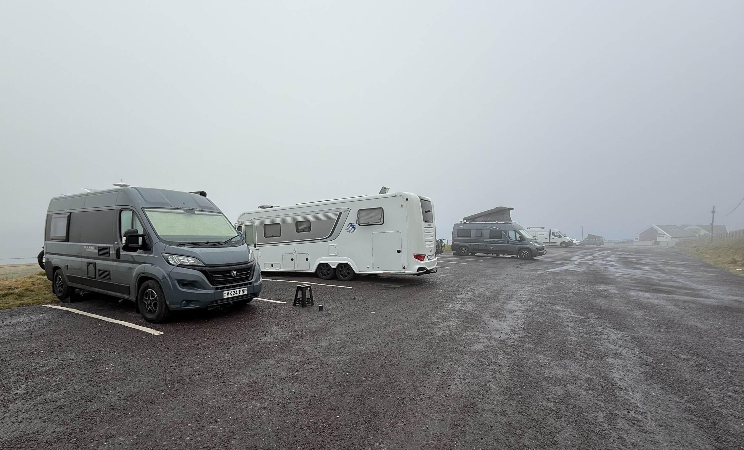 Campervans parked at Mizen Head as the morning mist begins to clear