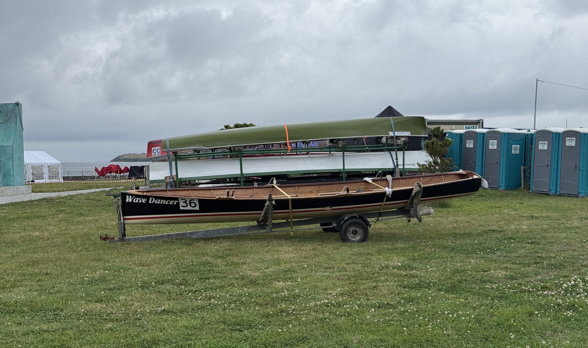Traditional coastal rowing boats stored on trailers beside Bantry Bay