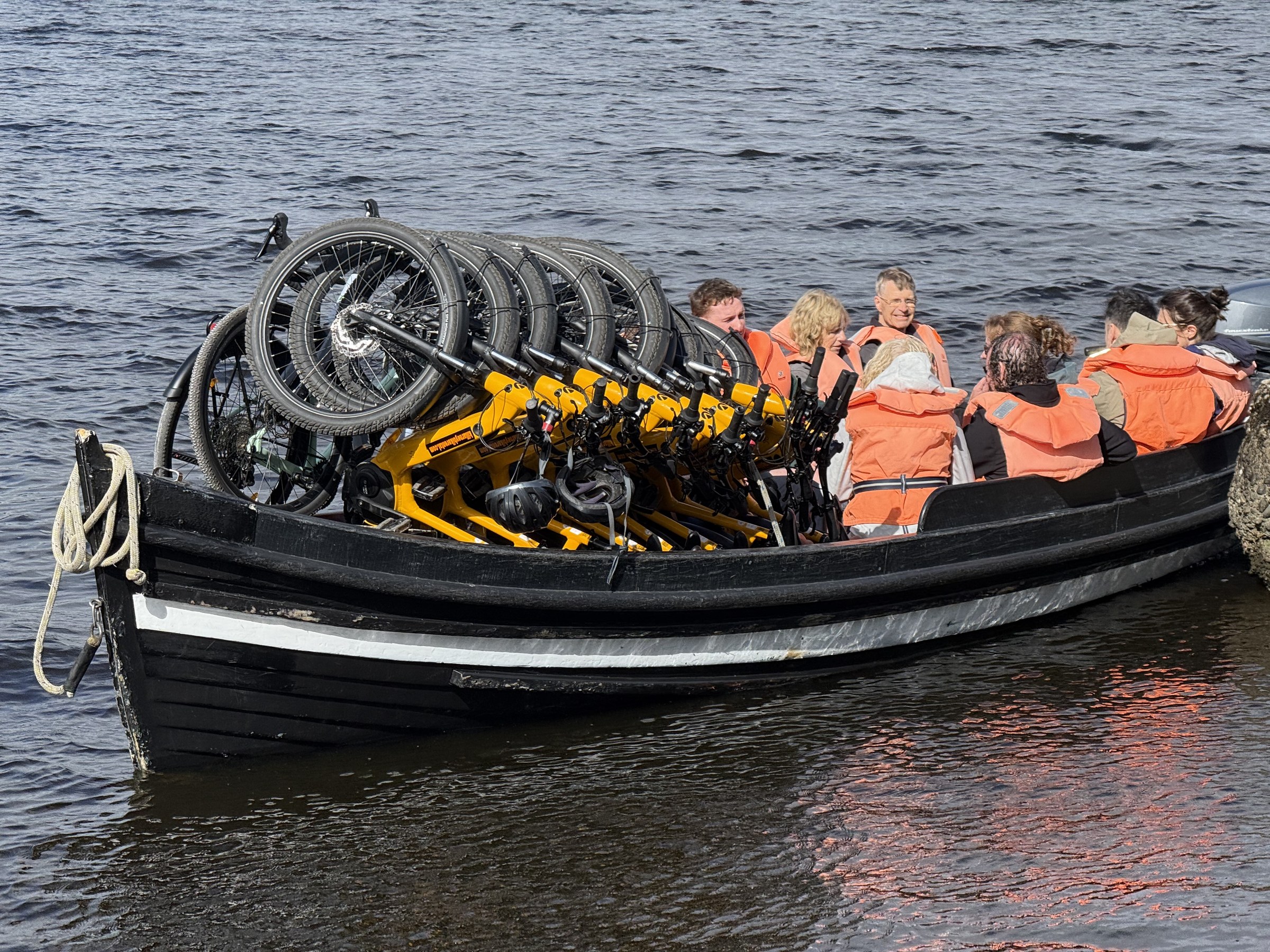 Passengers in life jackets aboard a boat carrying bicycles on Lough Leane