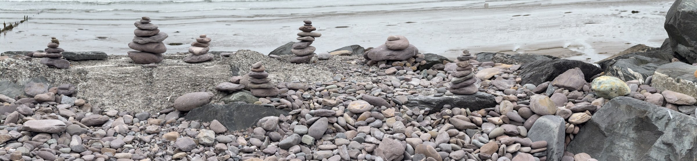 Small balanced-stone cairns arranged along Rossbeigh Beach