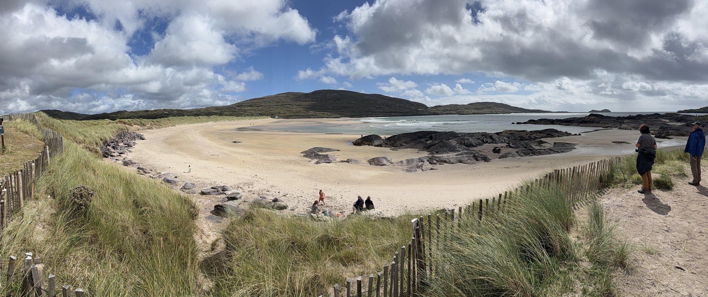 The wide sandy curve of Derrynane Beach beneath broken clouds