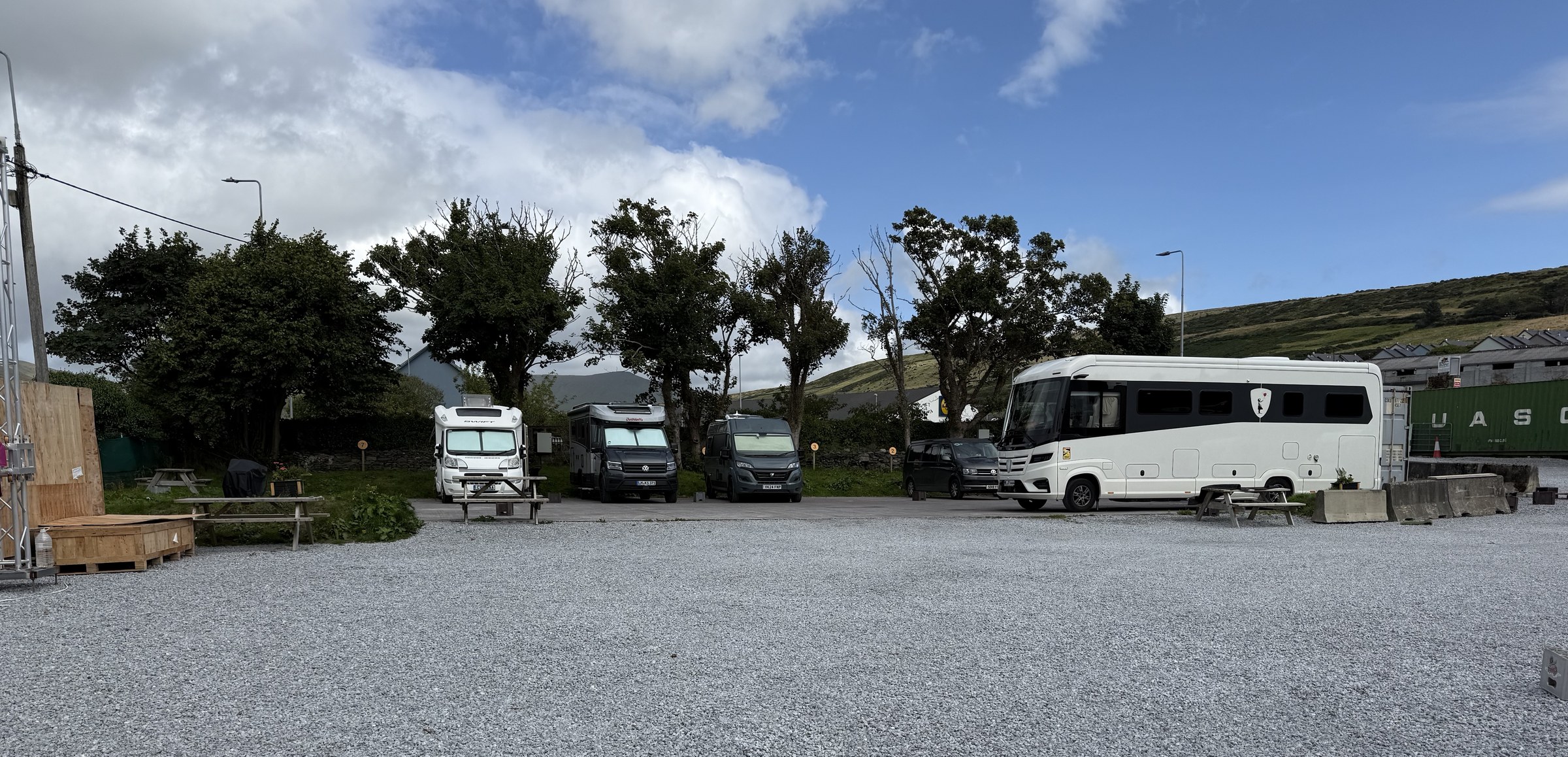 Campervans parked on the gravel at Dingle Bridge House Camping