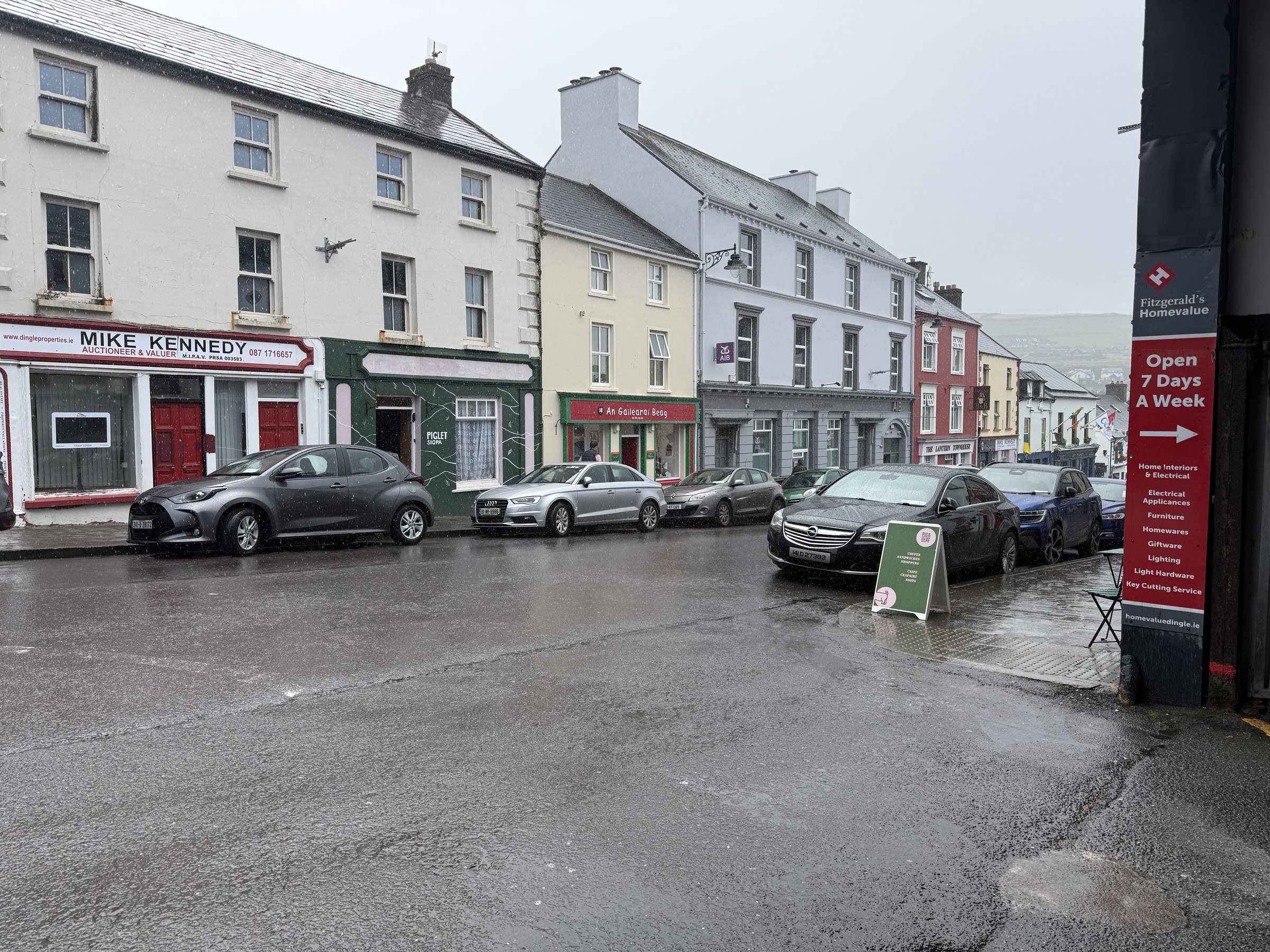 Rain falling on a street of colourful buildings in Dingle