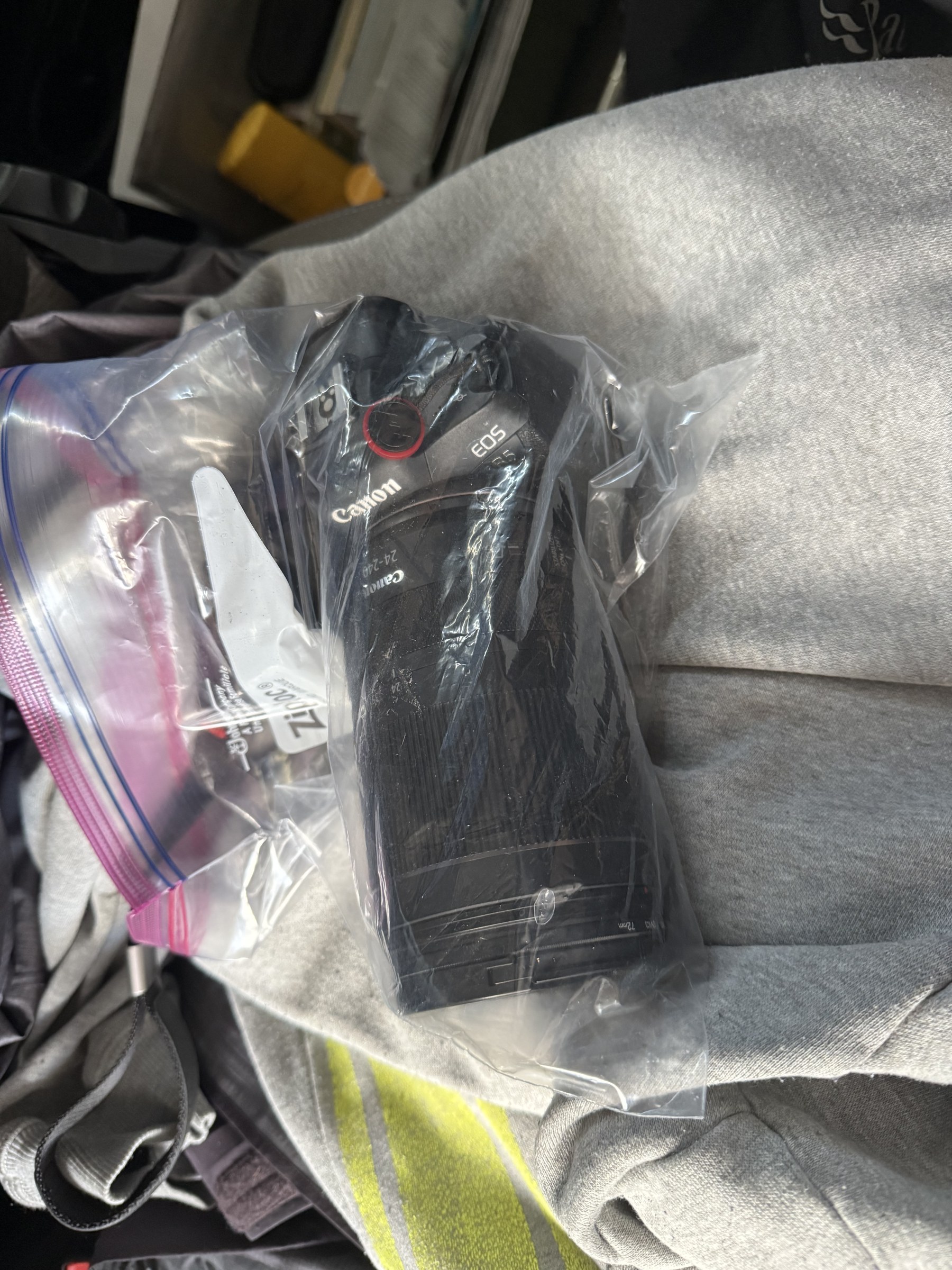 A Canon R5 camera wrapped inside a clear plastic bag