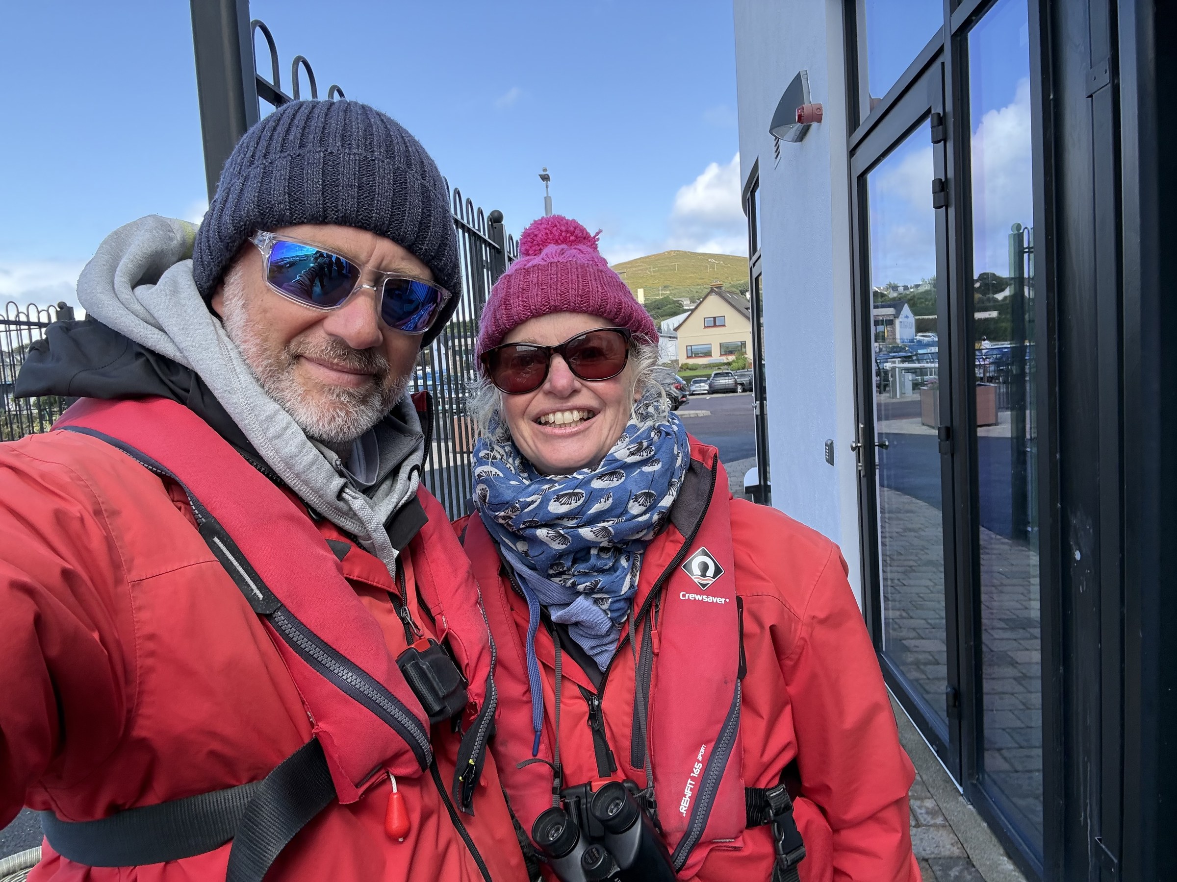 Sue and John wearing red waterproofs and lifejackets at Dingle Marina