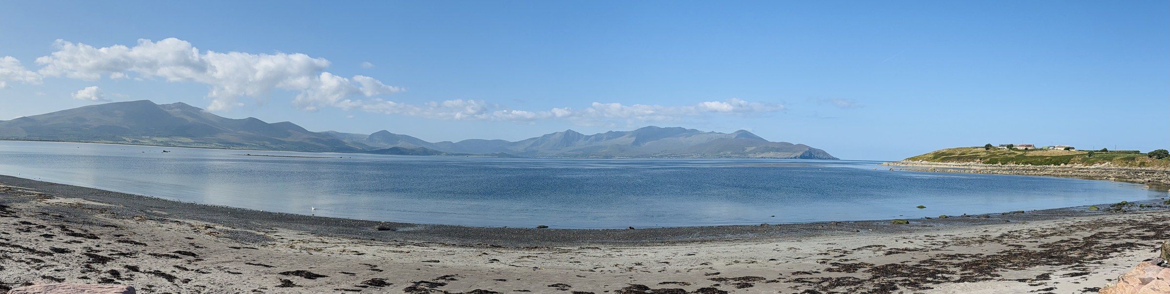 A wide panorama of the beach and mountains from the Maharees Peninsula