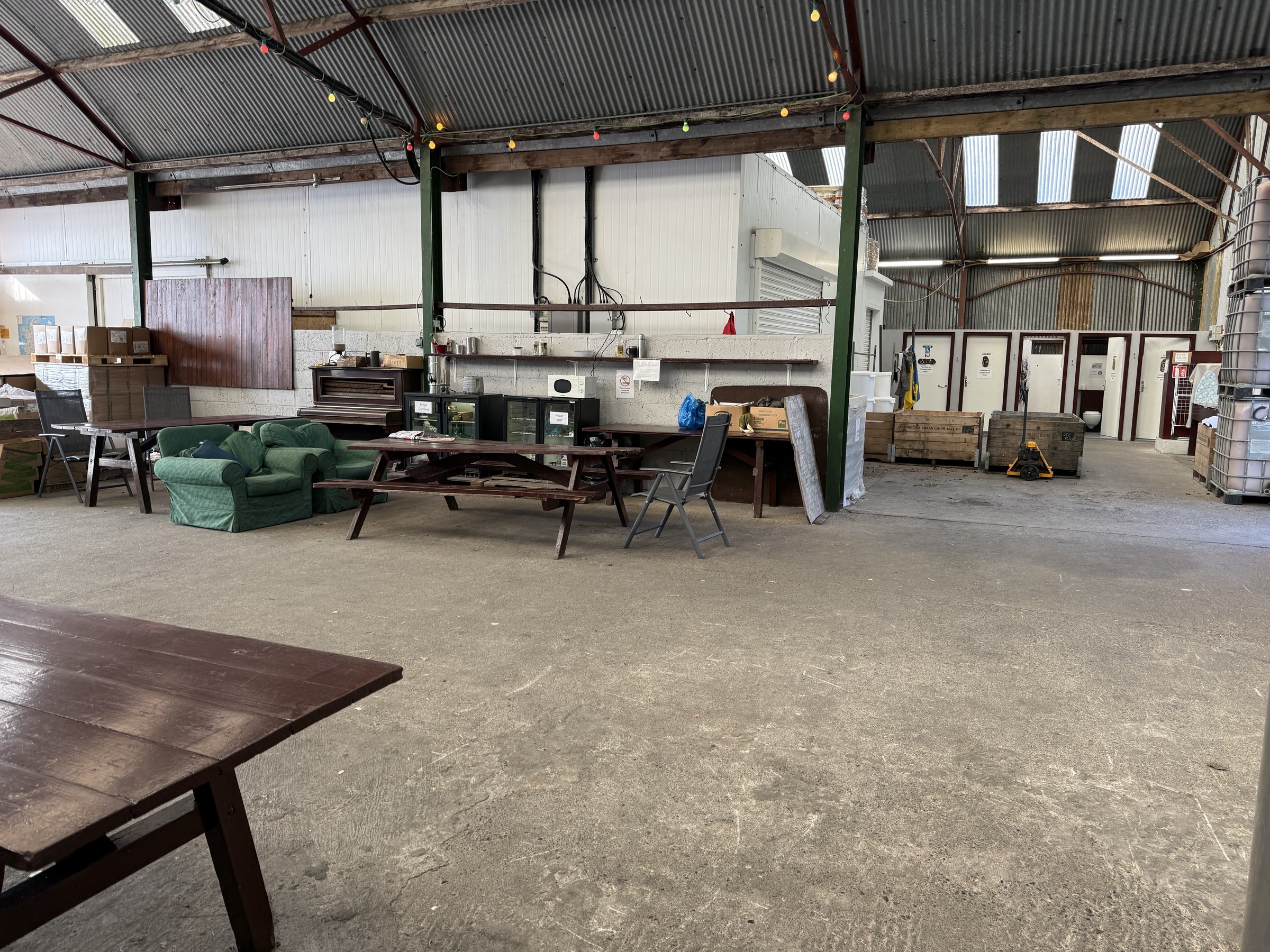 Tables, chairs and kitchen facilities inside the campsite's open-sided shed