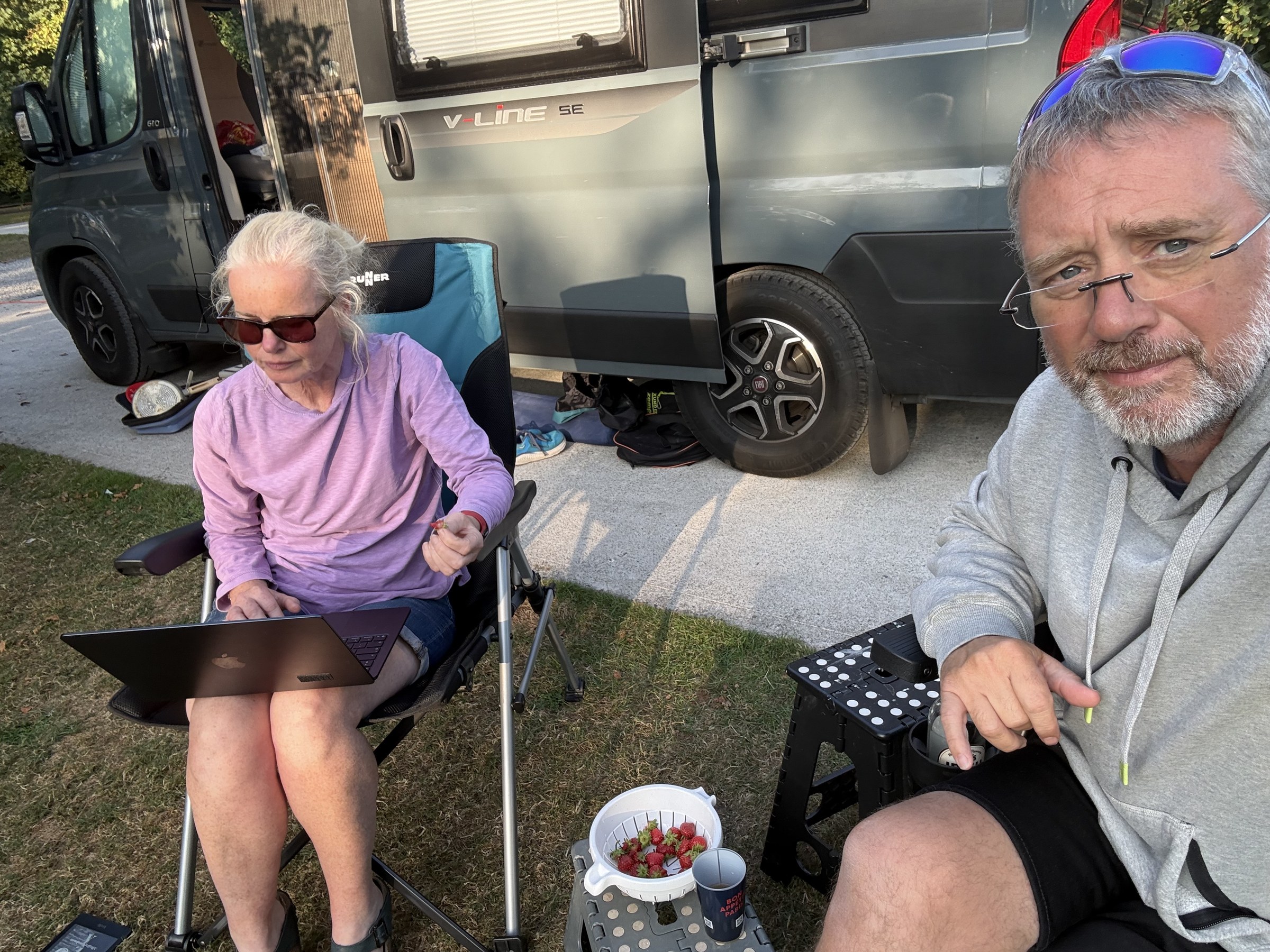 Sue and John eating bowls of strawberries beside Ollie