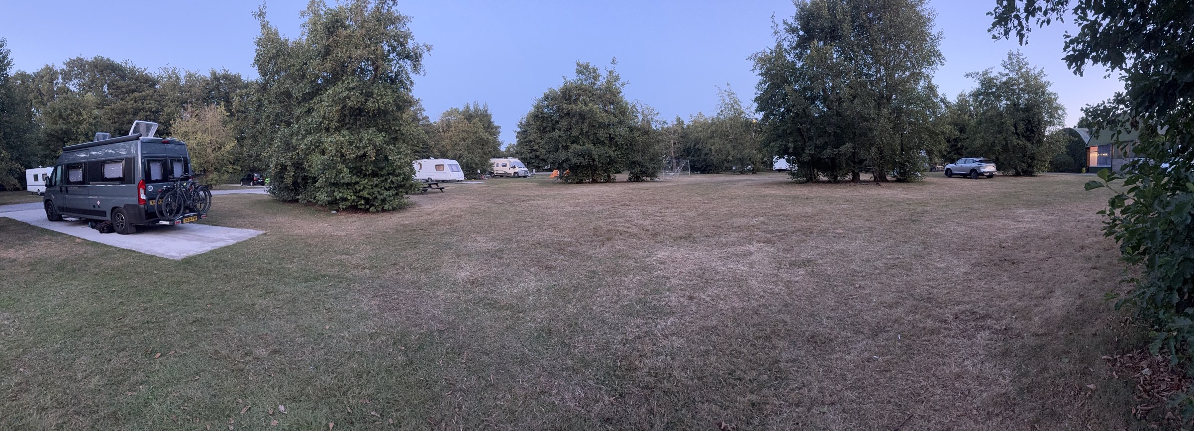 A wide evening view across the pitches at the Apple Farm campsite