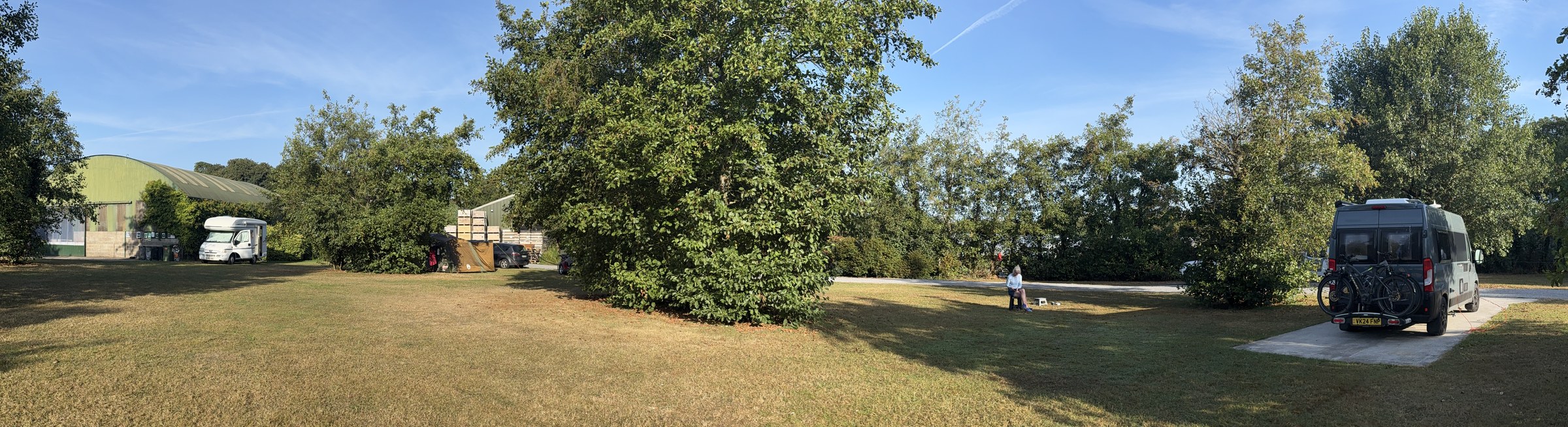 A wide morning panorama across the Apple Farm campsite