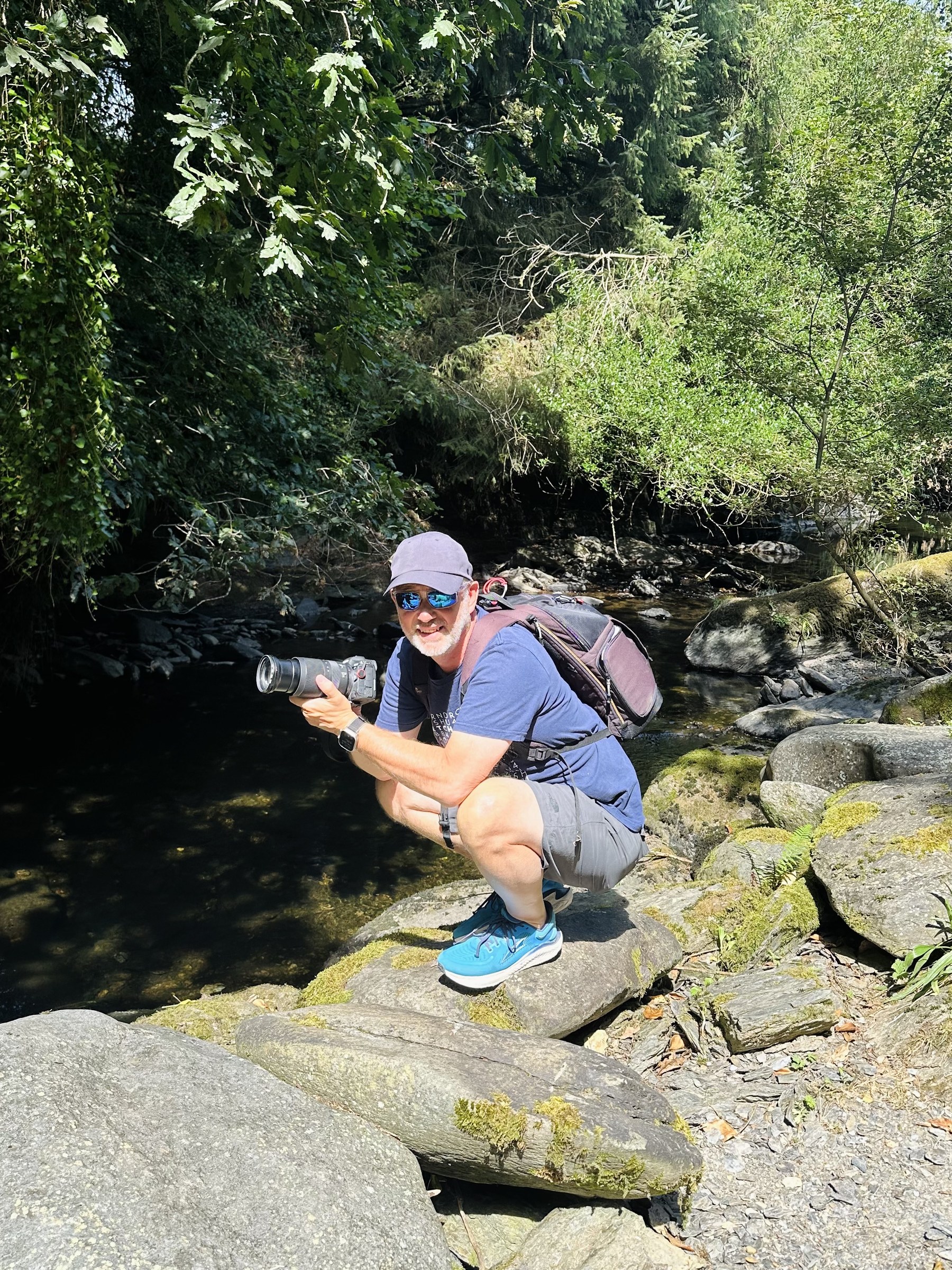 Sue sitting beside the River Ilen with her camera