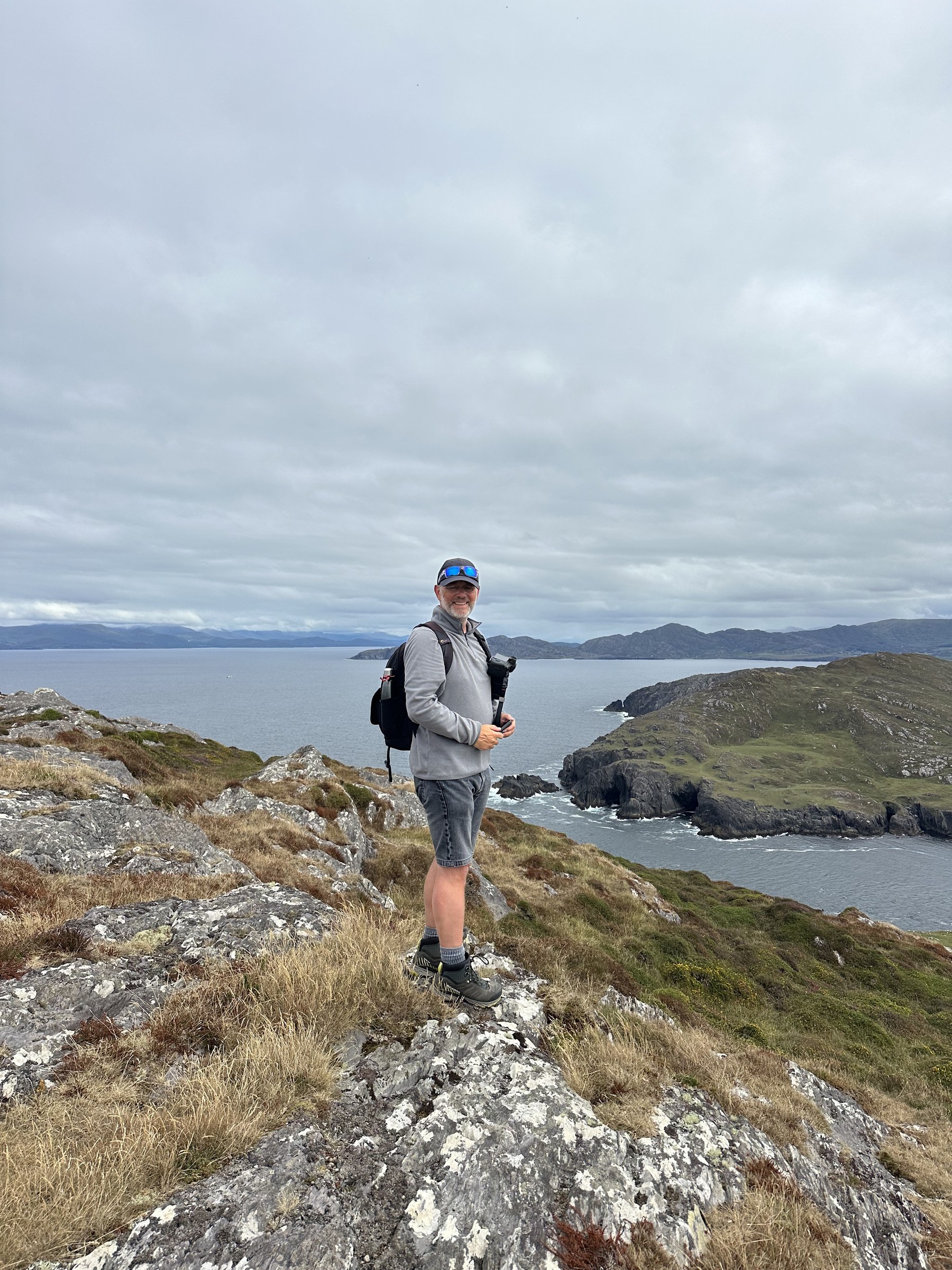John standing on the rocky hillside overlooking the island coast