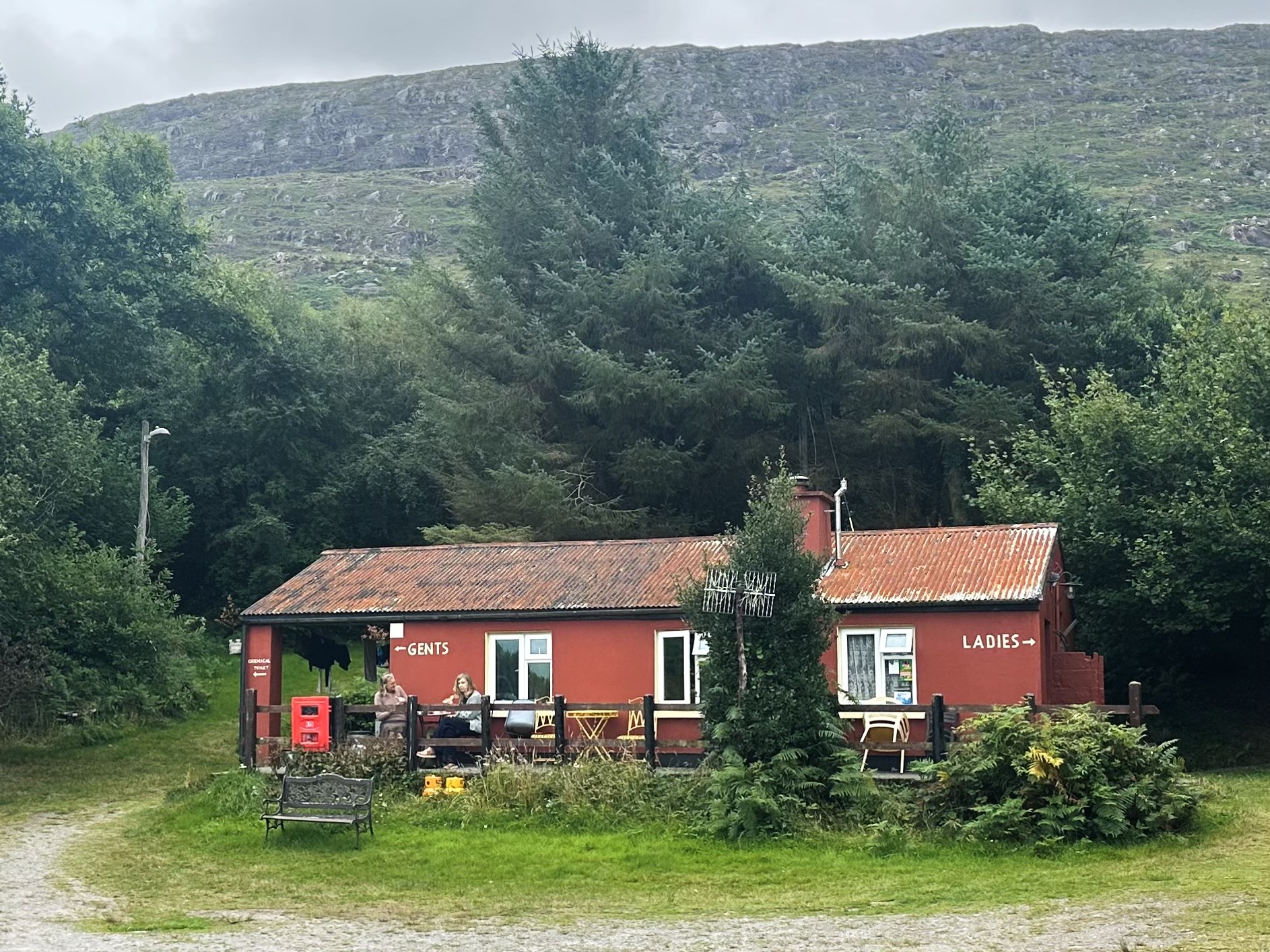 The red amenities building among trees at Creveen Lodge campsite