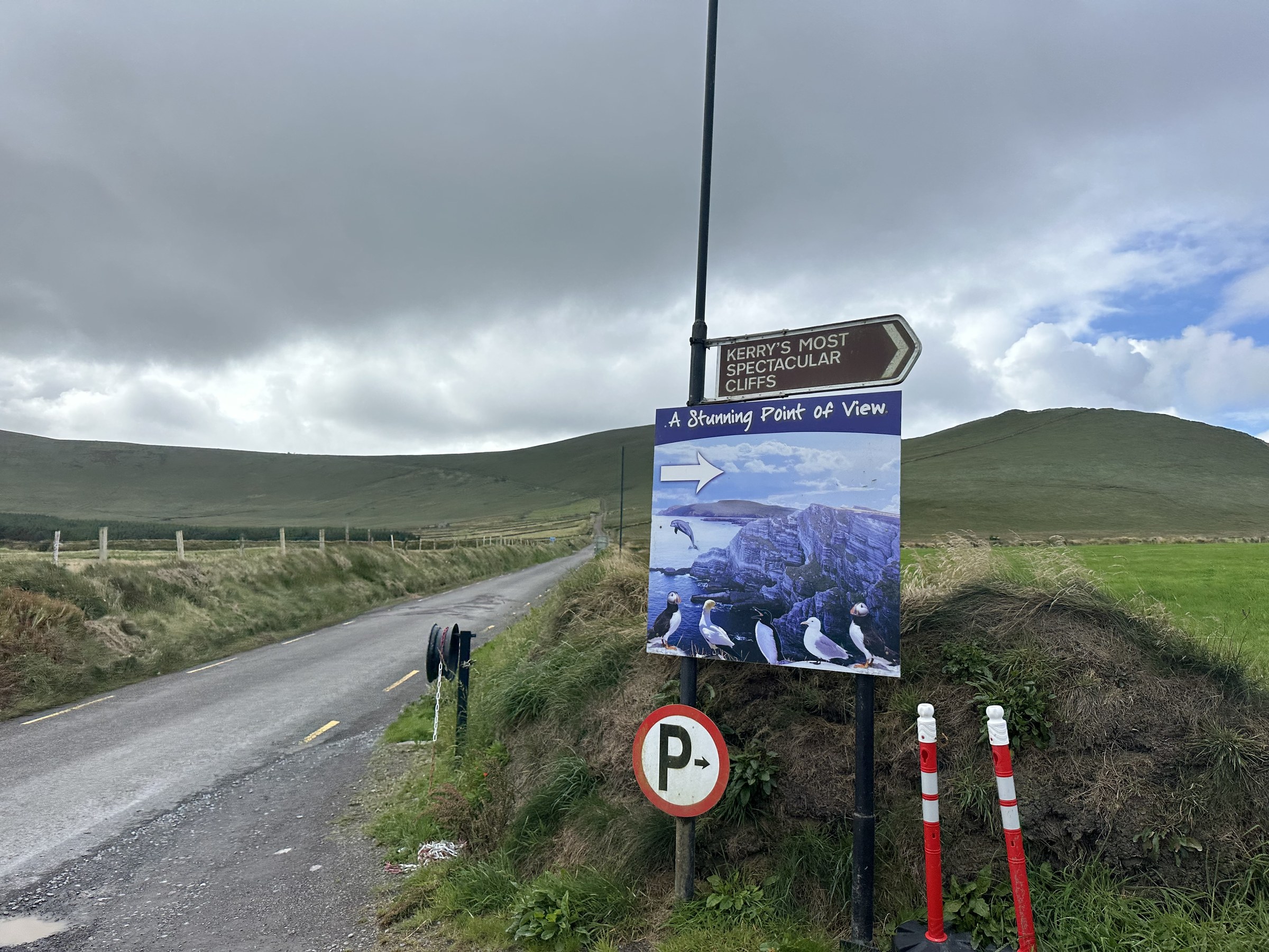 Roadside signs pointing along a narrow lane to the Kerry Cliffs
