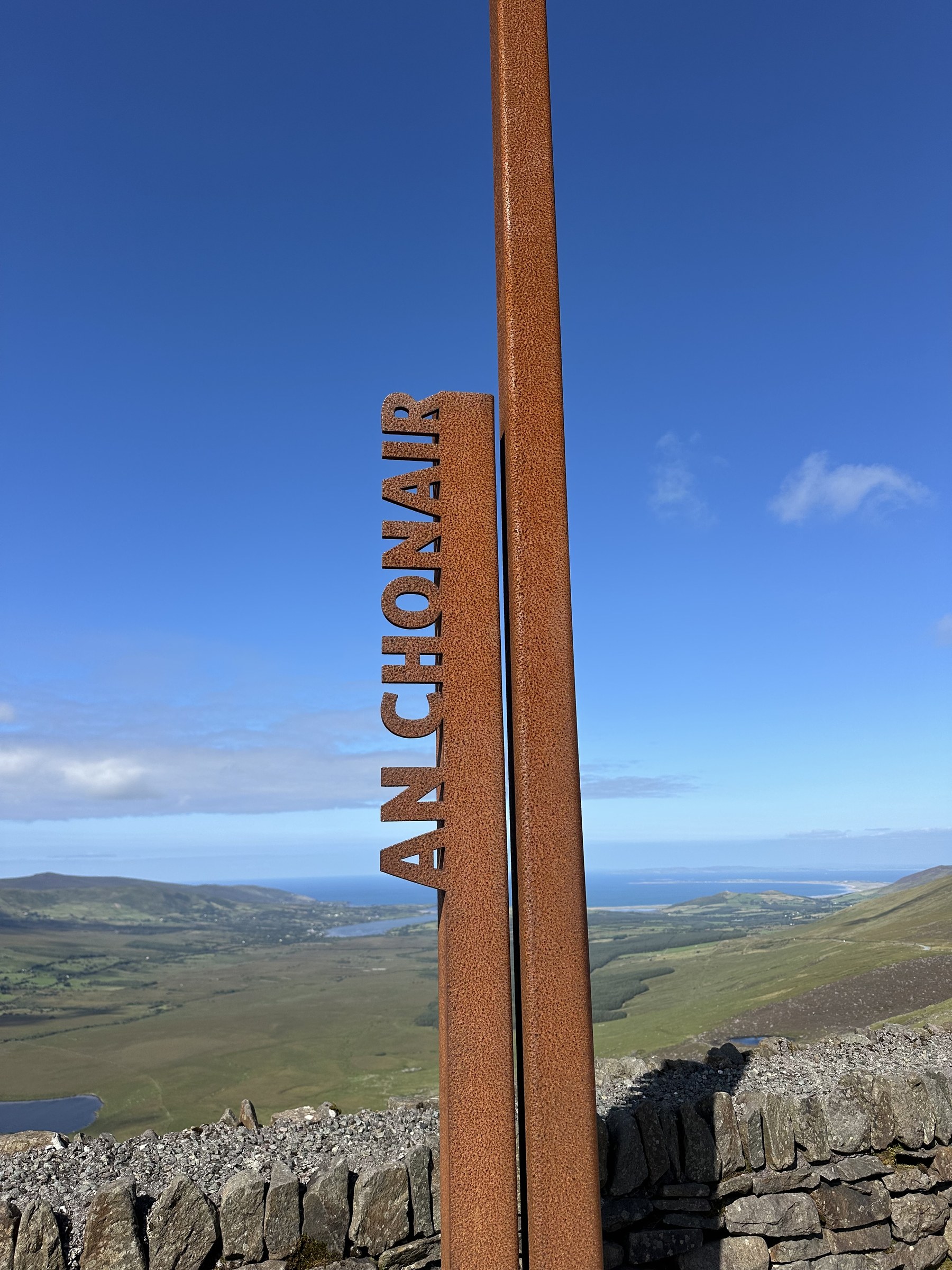 The rusted An Chonair marker at the Conor Pass viewpoint