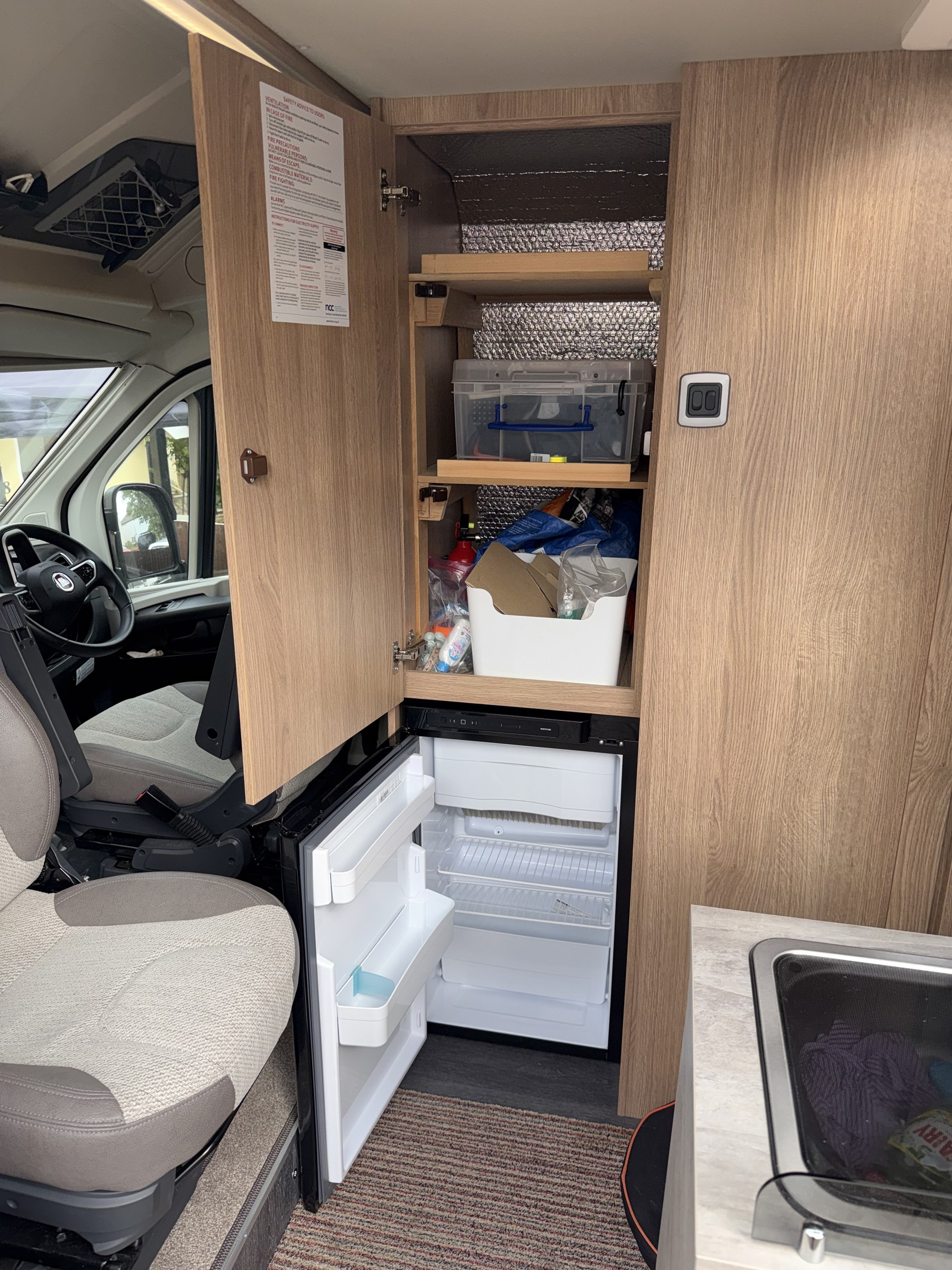 Ollie-II's fridge and the storage cupboard above it standing open