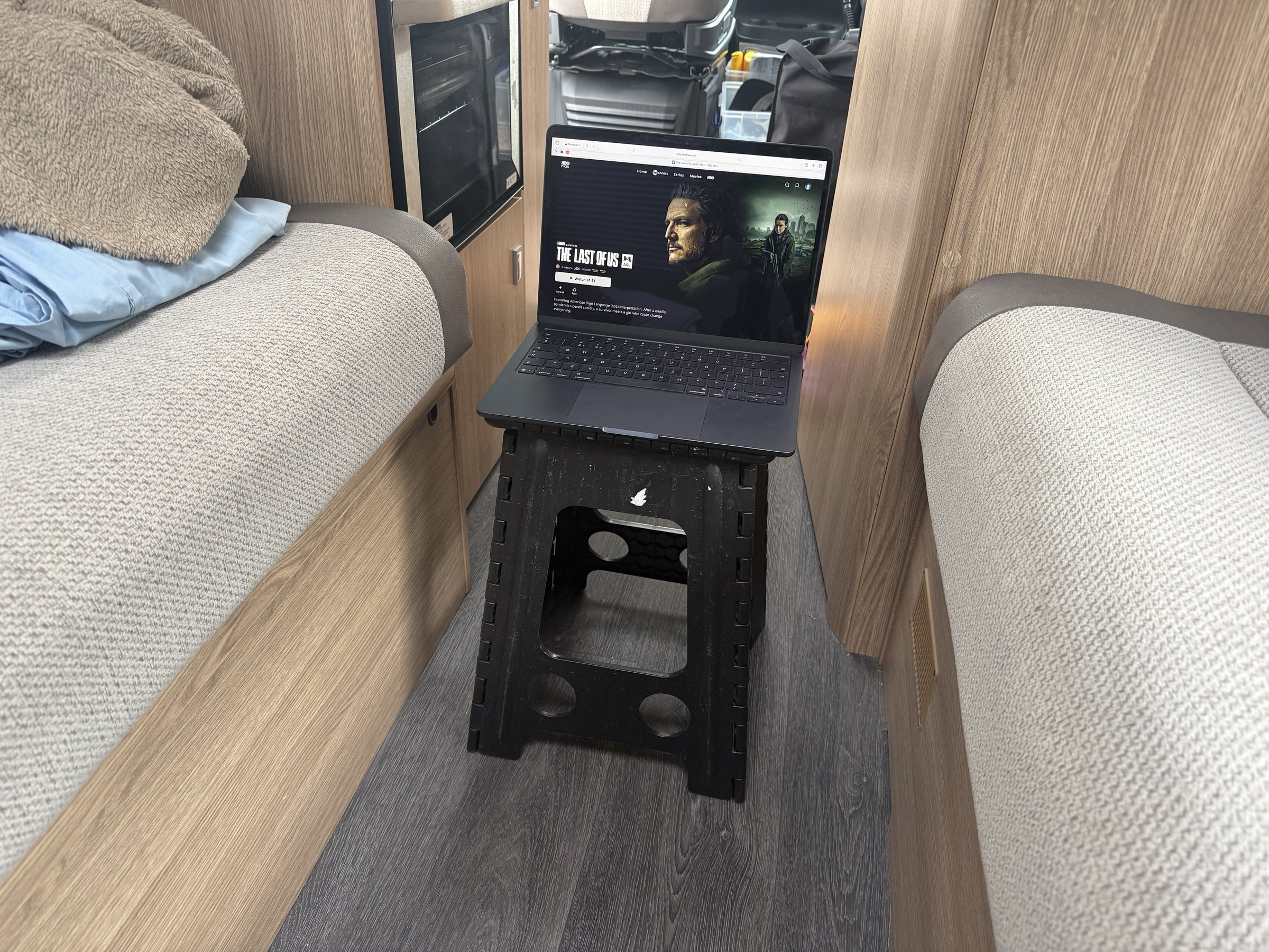 A laptop balanced on one of our folding stools for evening viewing